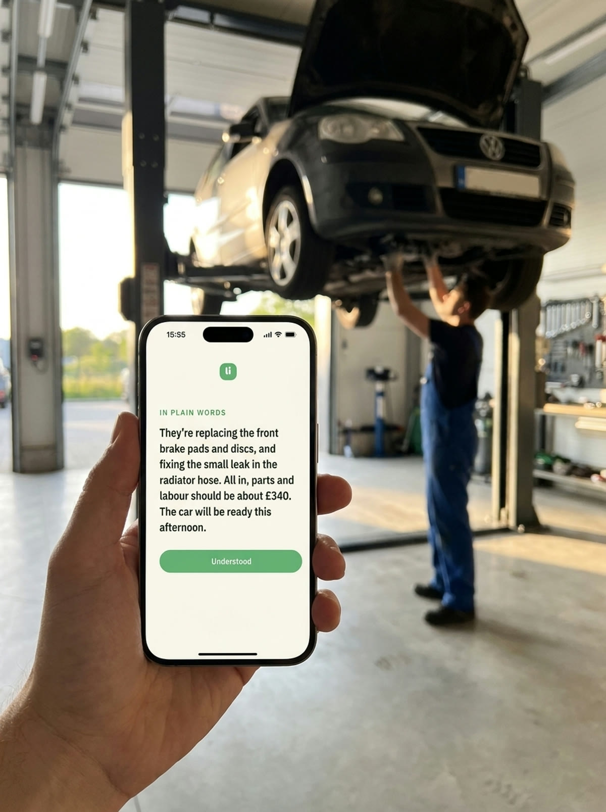 Holding Listenin at the garage while a mechanic works on a car raised on a lift